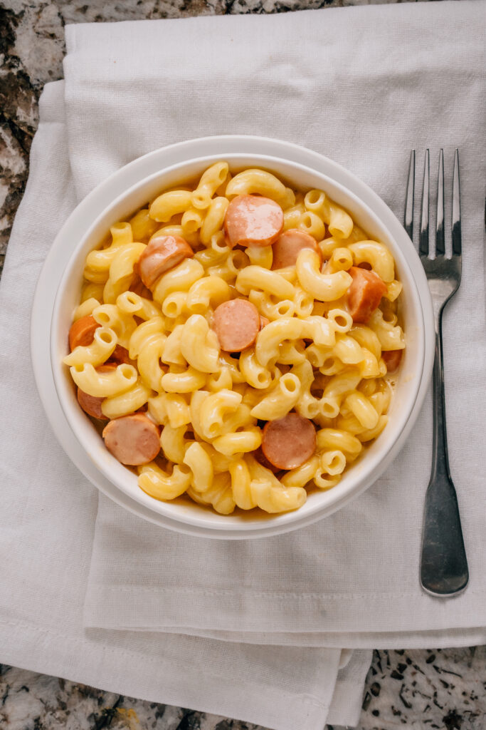 Crockpot mac and cheese with hotdogs in a bowl overview