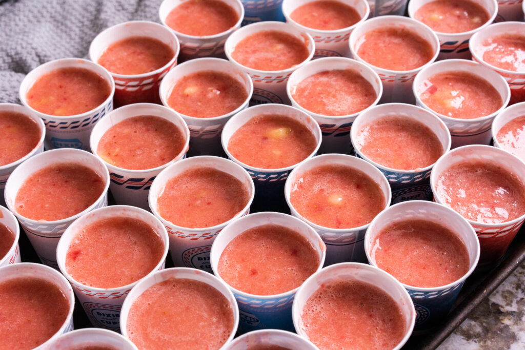A tray of individual serving size fruit freeze ups show from the side ready to be froze.