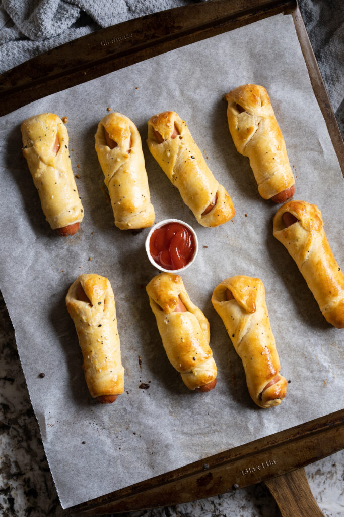 Eight mummies in a blanket or hot dogs baked in crescent rolls hot and ready to eat!