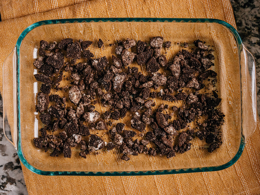 Step 1: A layer of crushed Oreos in 9x13in pan.