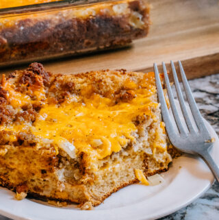 Single slice of fully bake breakfast casserole on a plate. A nice brown outer crust and cheesy melt-in-your-mouth center. Yum!