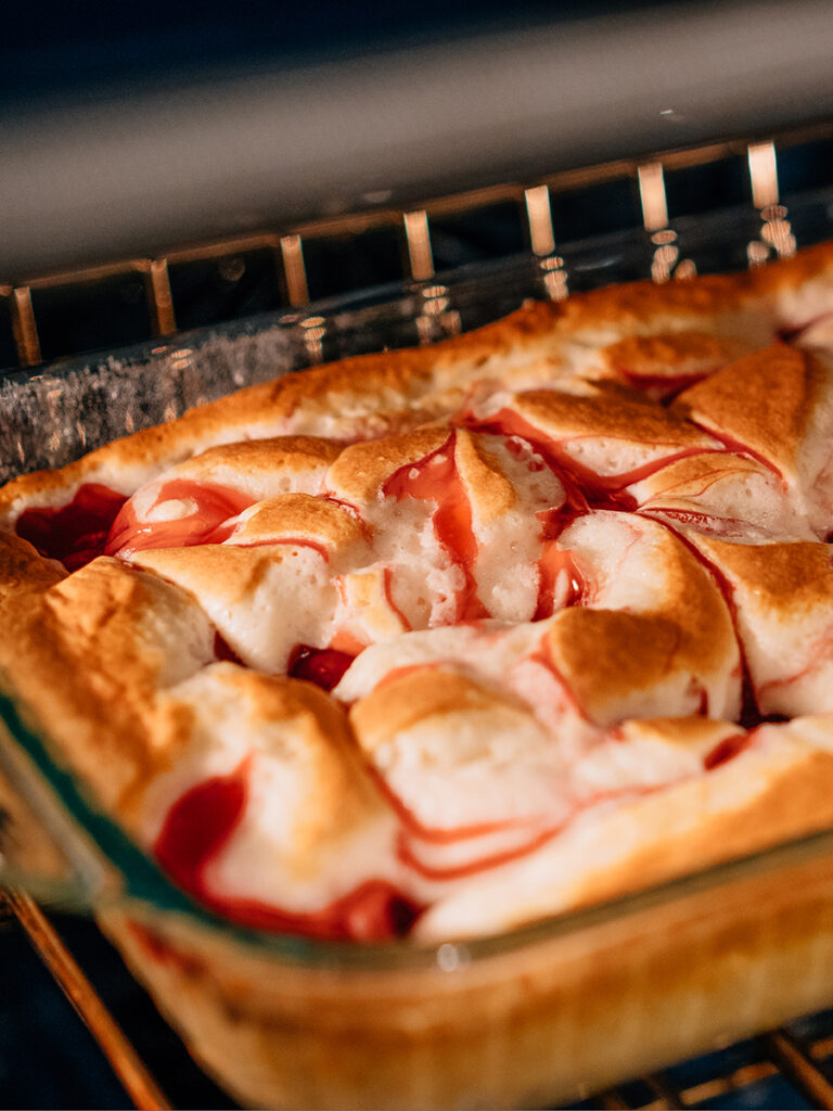 A cherry brunch cake baking in the oven.