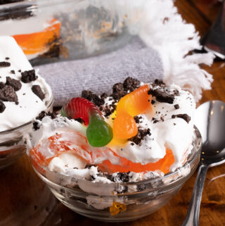A small bowl of this Halloween dirt dessert garnished with gummy worms coming out of the top of Oreos. A great spooky dessert!