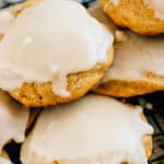 A pile of freshly baked fluffy cake-like pumpkin cookies topped with a simple and sweet glaze.