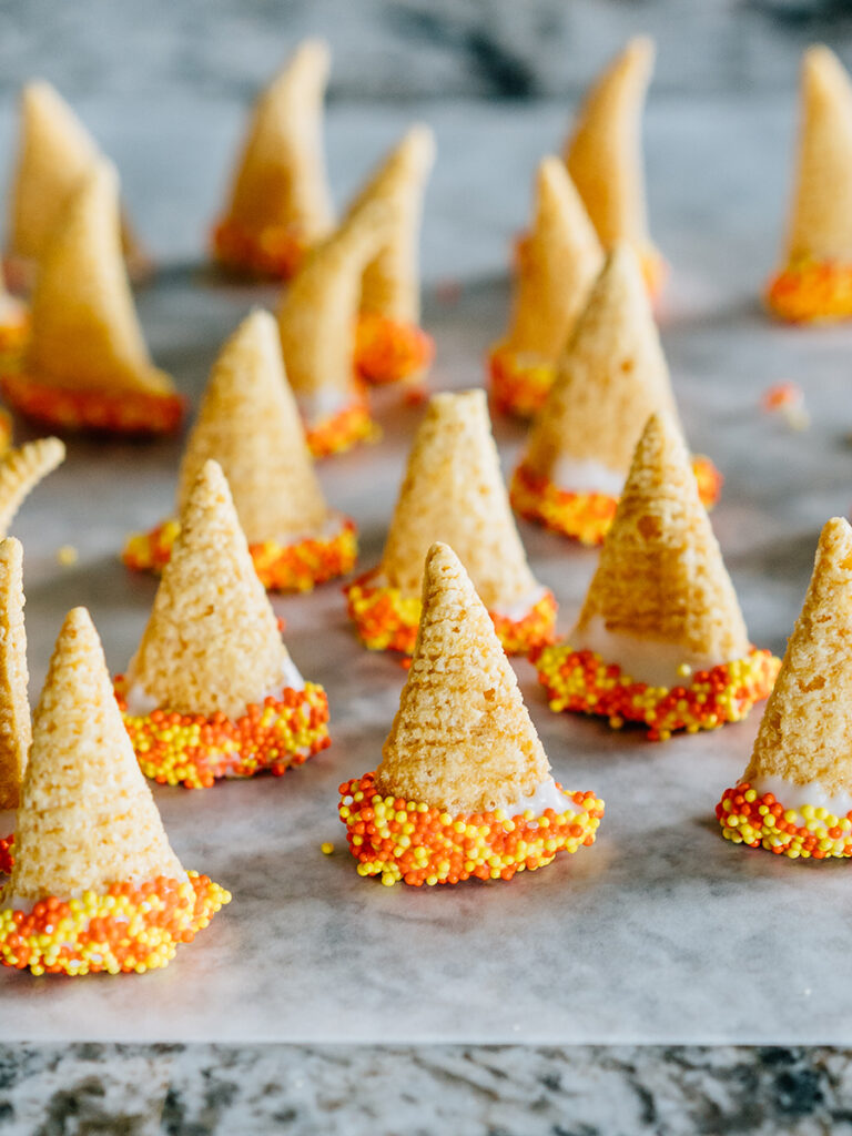 Buggles, white chocolate and sprinkles make witches hats! They are drying on wax paper here.
