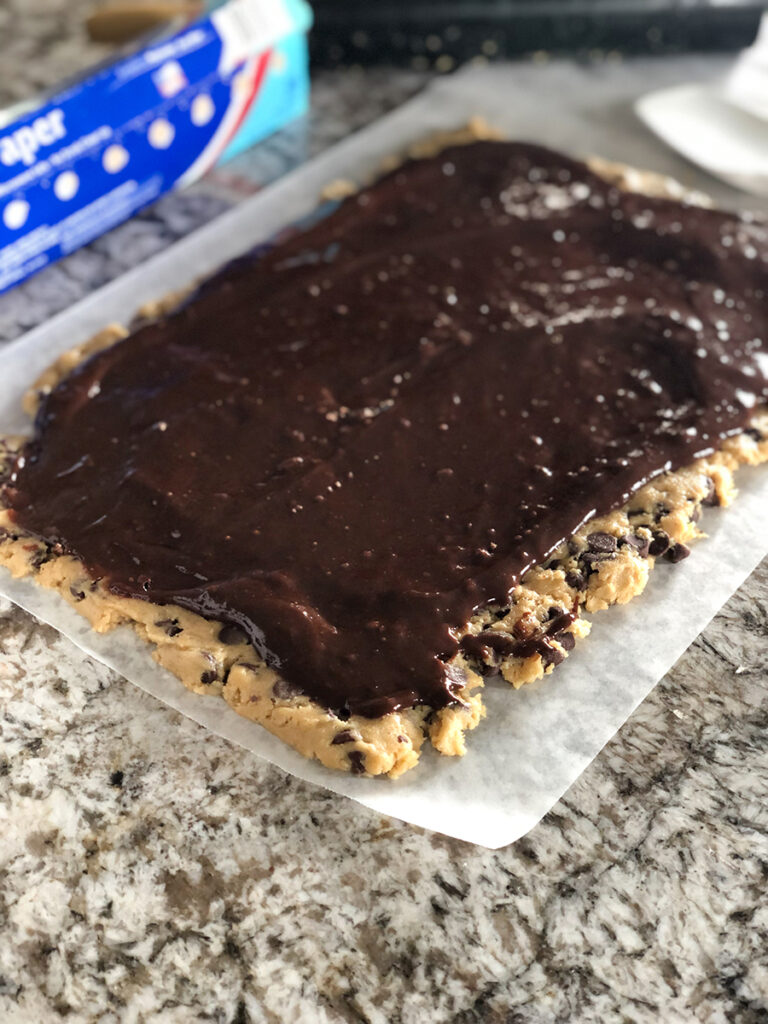 A sheet of cookie dough with brownie batter on top. The being of the easy brookie cookie!