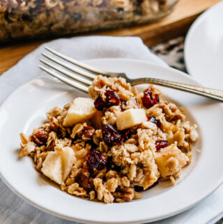 A plate of warm baked apple cranberry pecan oatmeal ready to eat.