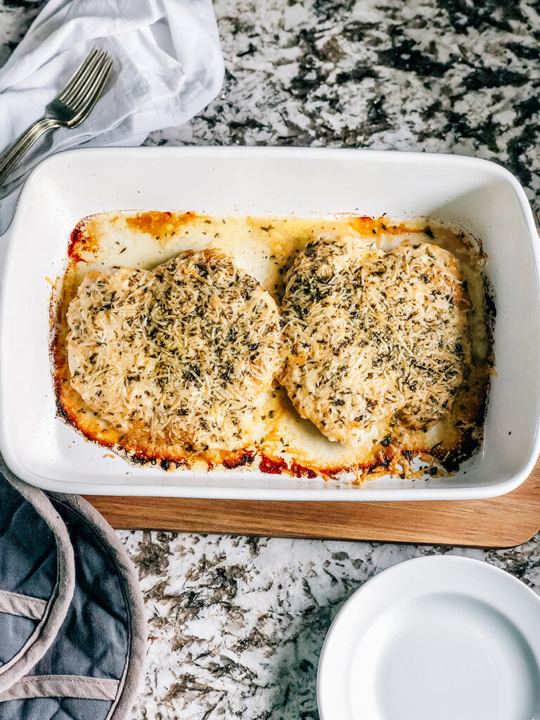 Baked garlic parmesan chicken in a baking dish hot from the oven.