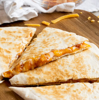 A warm and toasty salsa and cheese quesadilla cut into four triangles and ready to eat!
