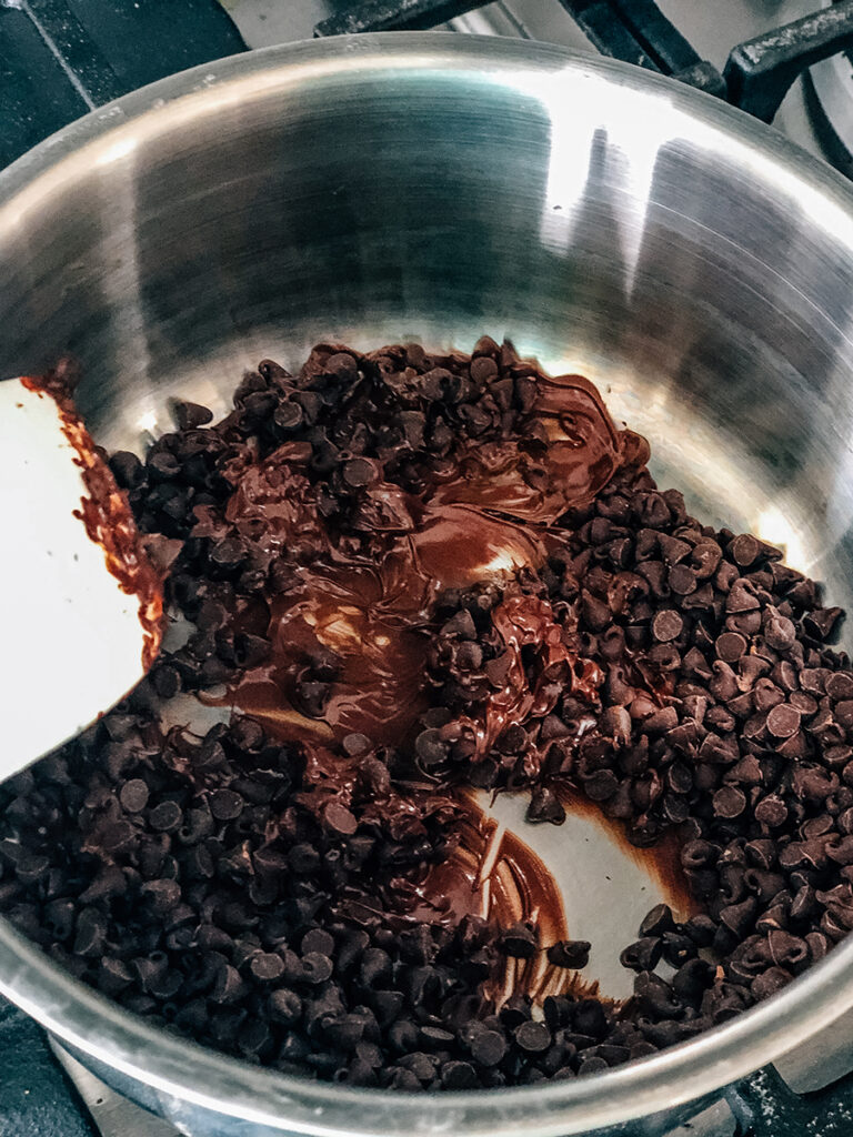Melting semi-sweet chocolate chips in a small saucepan.