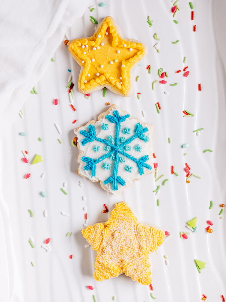 Star and snowflake Christmas sugar cookies on a platter.