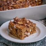 A Golden Graham S'mores bar on a plate with the 9x13 inch pan of them in the background.