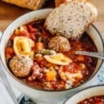 Easy Italian meatball and cheese tortellini soup garnished with parmesan cheese and a crusty bread slice. The perfect warm soup!