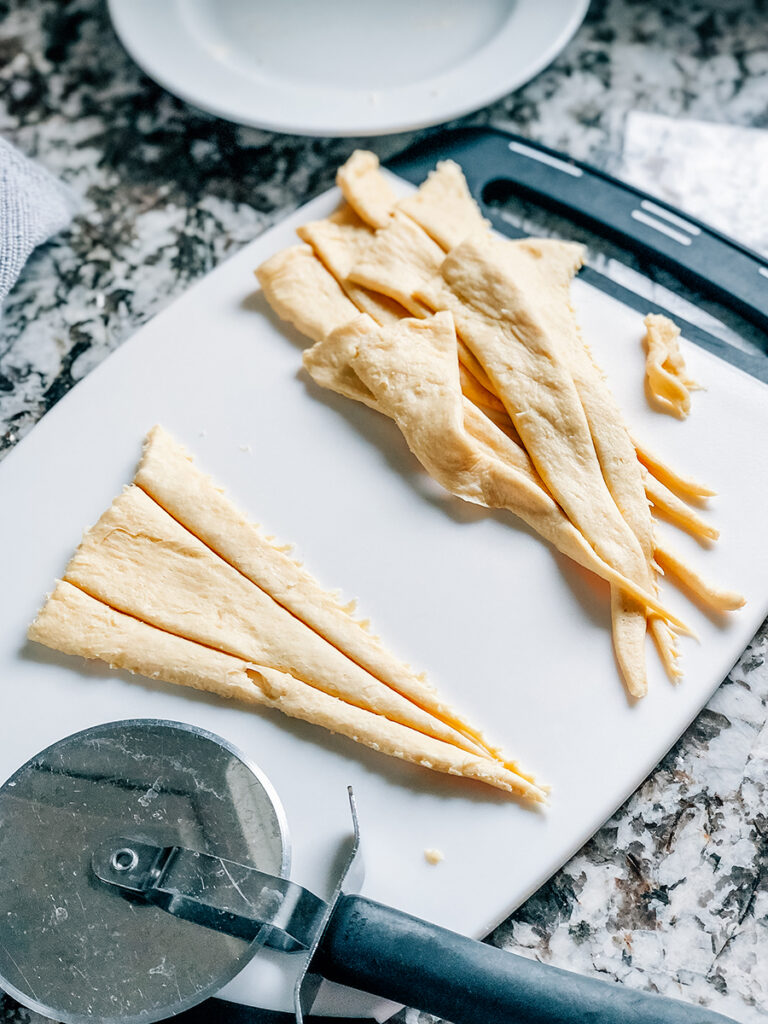 Take the four remaining crescent rolls and cut them into thirds with a pizza cutter.