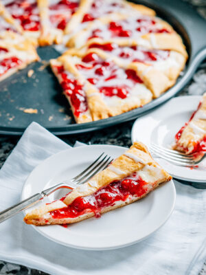 A slice of cherry and cream cheese crescent ring dessert.