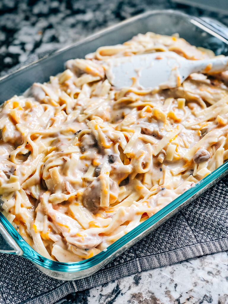 The egg noodles, cream of mushroom soup, sliced mushrooms, tuna, cheddar cheese, and milk mix together and spread out into a 9x13 in baking dish.