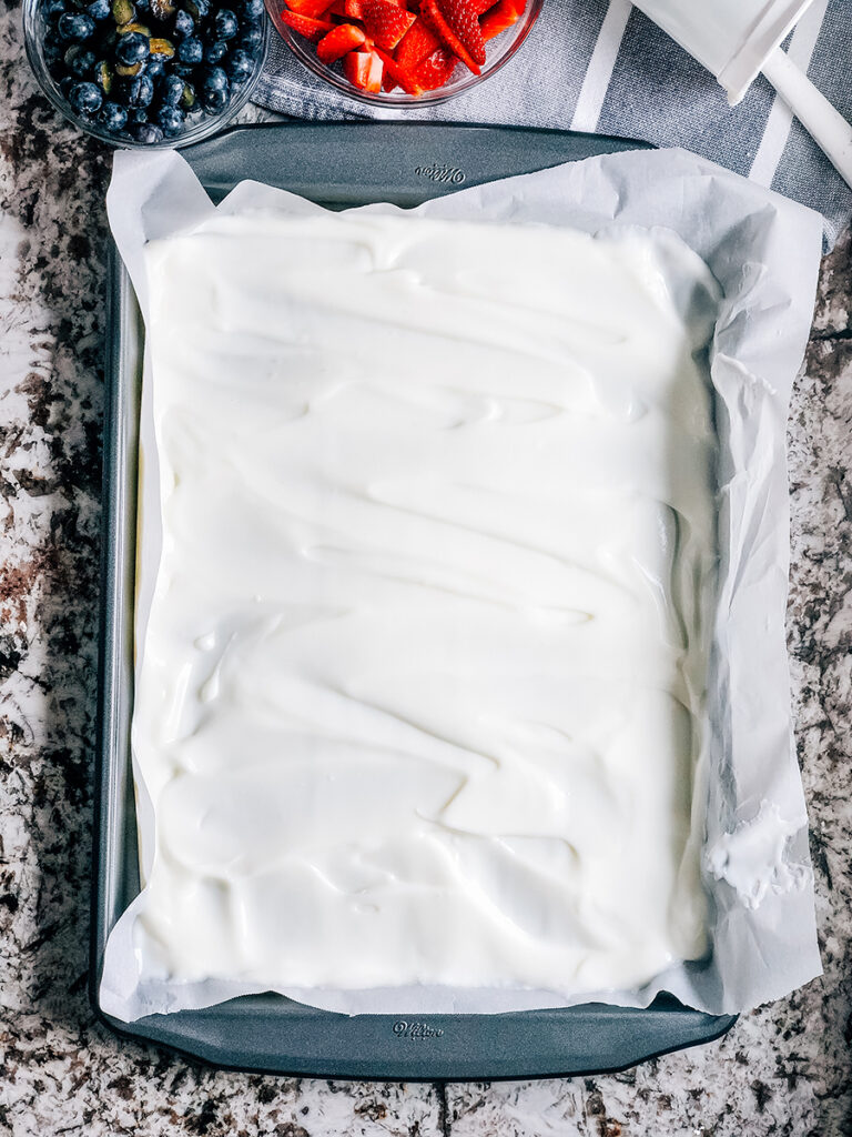 Vanilla yogurt spread into a thin sheet on parchment paper lined 10 x 17 inch baking sheet.