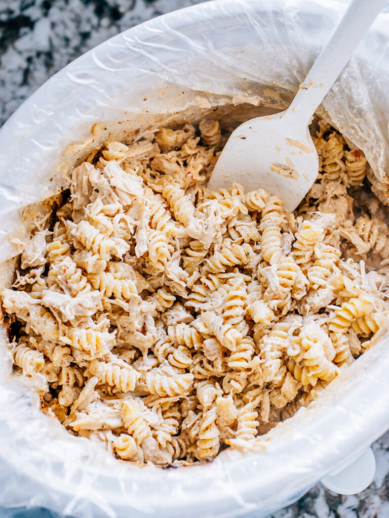 The rotini pasta added and then stirred to the garlic parmesan shredded chicken.