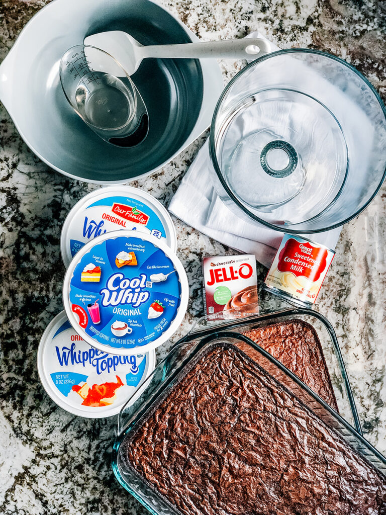 Ingredients to a delicious brownie trifle: a lot of Cool Whip, a chocolate pudding packet, water, sweetened condensed milk, and 2- 9x13-in pans of brownies made per box instructions.