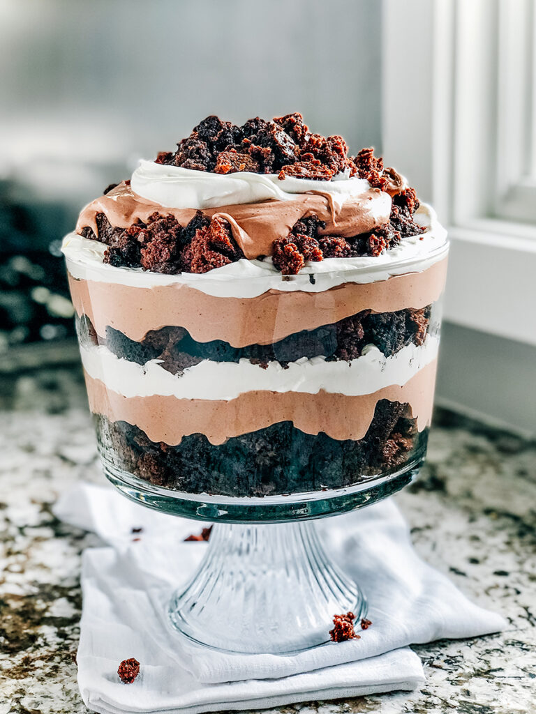 Repeat layers of brownie, chocolate pudding layer, and cool whip three times and end with more brownie crumbles for a complete brownie trifle.