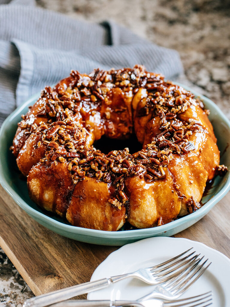 Side view: A yummy butterscotch coffee cake flipped from the bundt cake pan with caramelized pecans and a sweet butterscotch glaze on top!