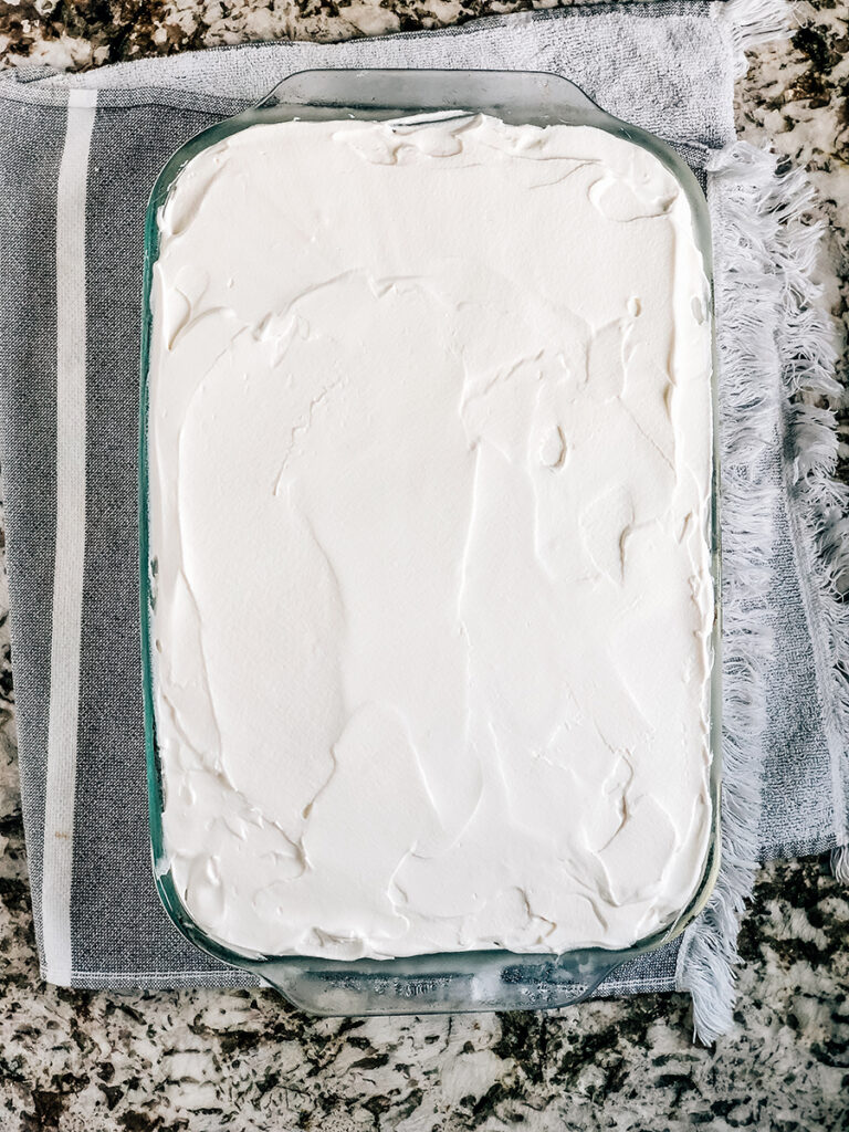 Top the ice cream cake with a layer of thick whipped topping.