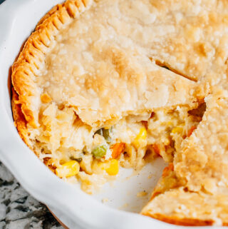 The inside view of a chicken pot pie with shredded chicken, cheddar cheese and vegetables.