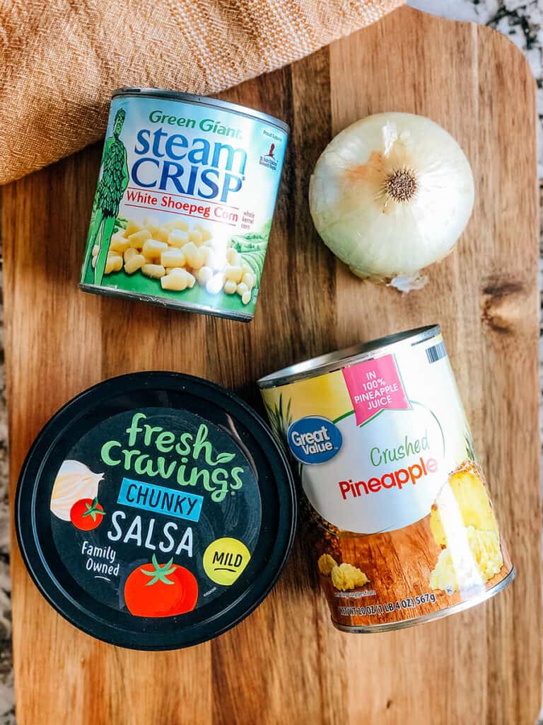 The ingredients to pineapple corn salsa, a super easy summer salsa recipe: Crushed pineapple, chunky salsa, white shoepeg corn, and chopped sweet onion.