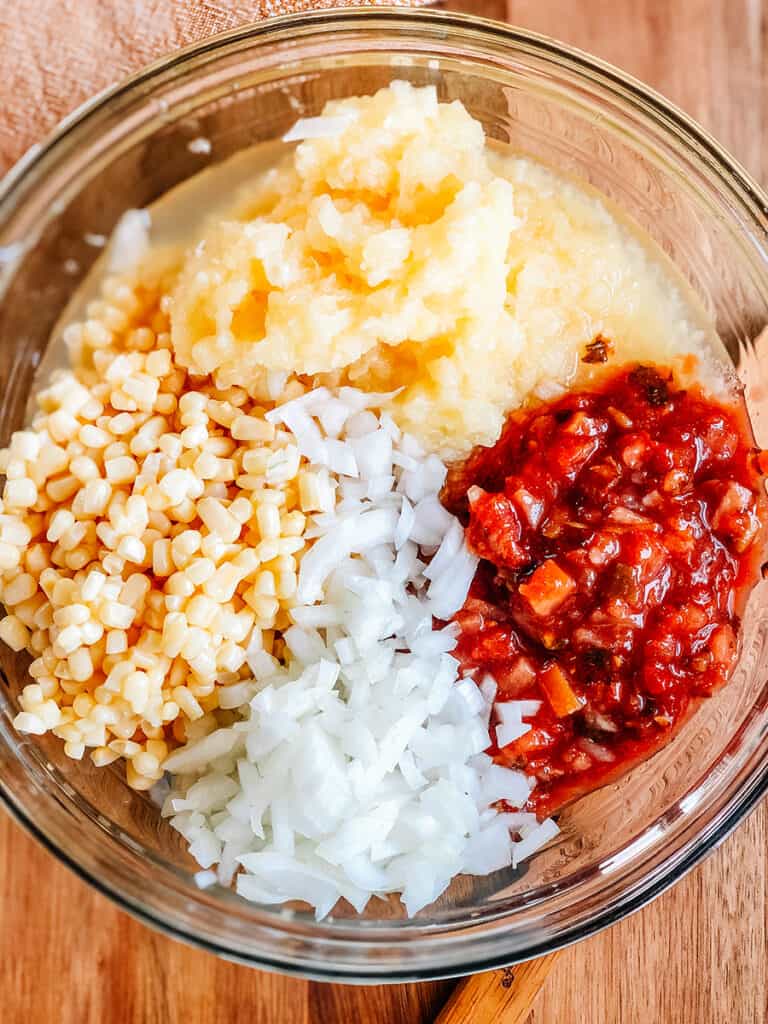 A medium bowl showing the four ingredients to this easy salsa recipe.