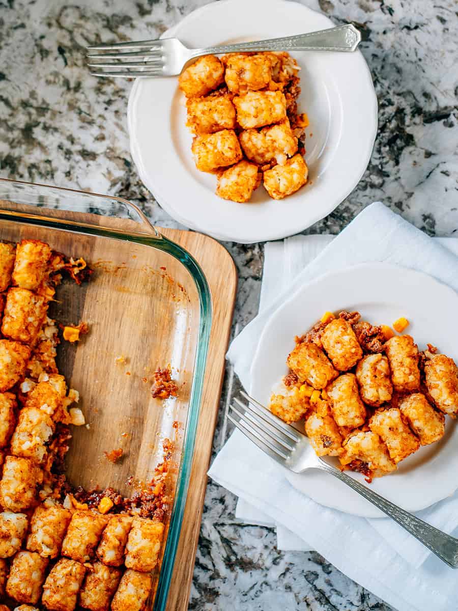 Assiettes de casserole de Tater Tot aux Sloppy Joes à côté du plat de la casserole restante.