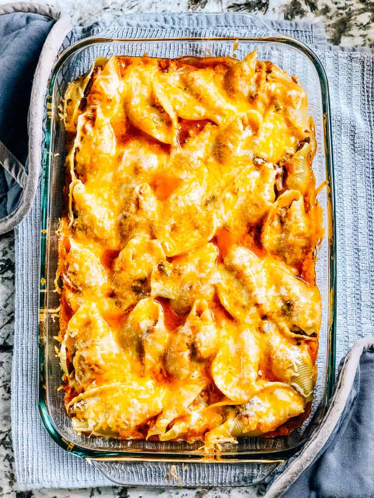 Completely baked and cooling Mexican stuffed shells in a baking dish.