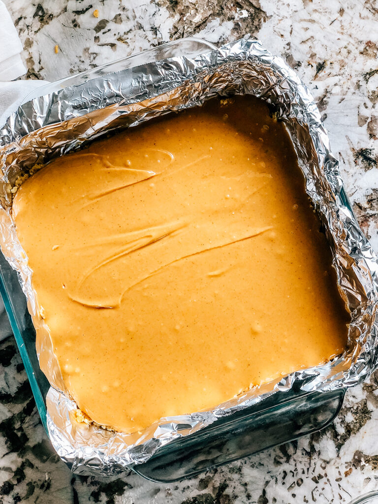 The filling completed and poured onto the crust of these no bake peanut butter bars.