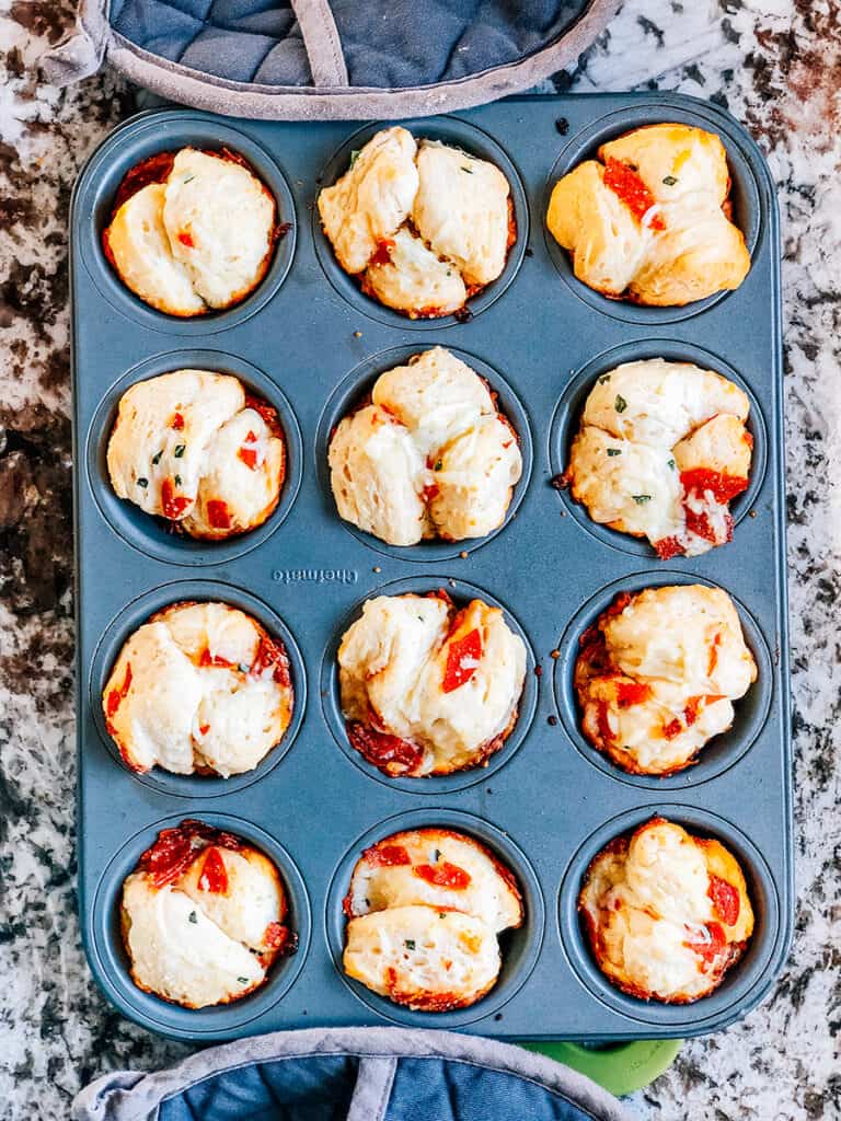 Freshly baked yummy pull apart pizza muffins still in the muffin tins.