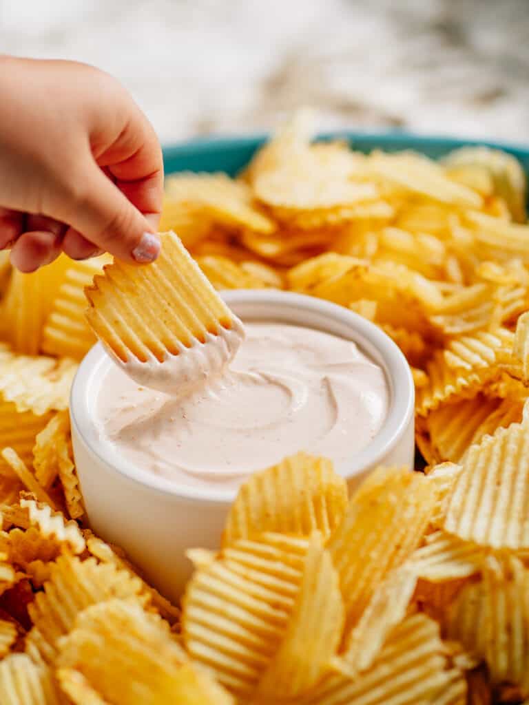 A dipped chip loaded with chip dip for a savory and salty bite.