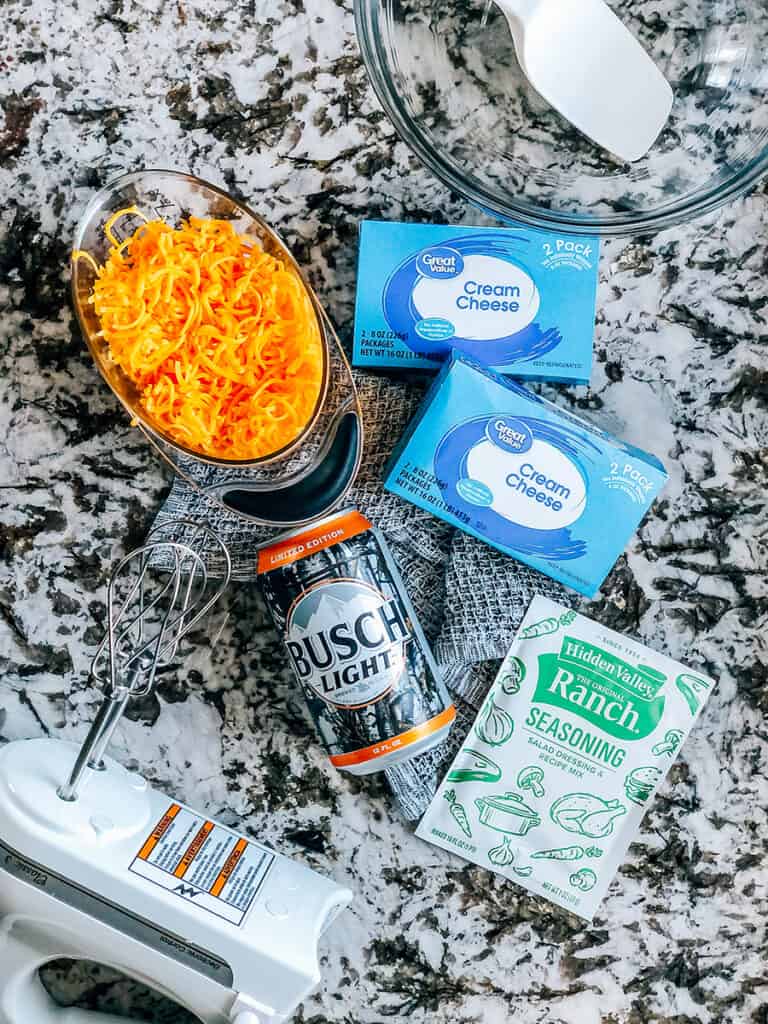 The ingredients to this simple beer dip: cream cheese, ranch seasoning packet, your favorite beer, and shredded cheddar cheese.