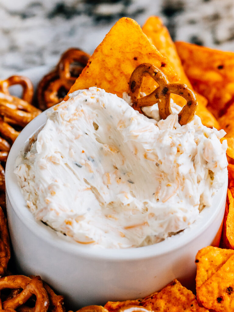 Creamy ranch beer cheese dip with a mini pretzel twist and dorito stuck in it make for the best game day munchie.