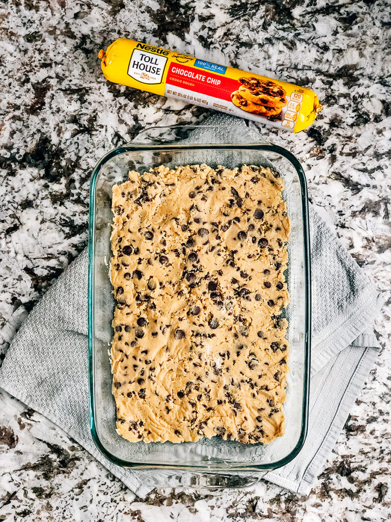 Step one: Flatten chocolate chip cookie dough into bottom of a baking pan.