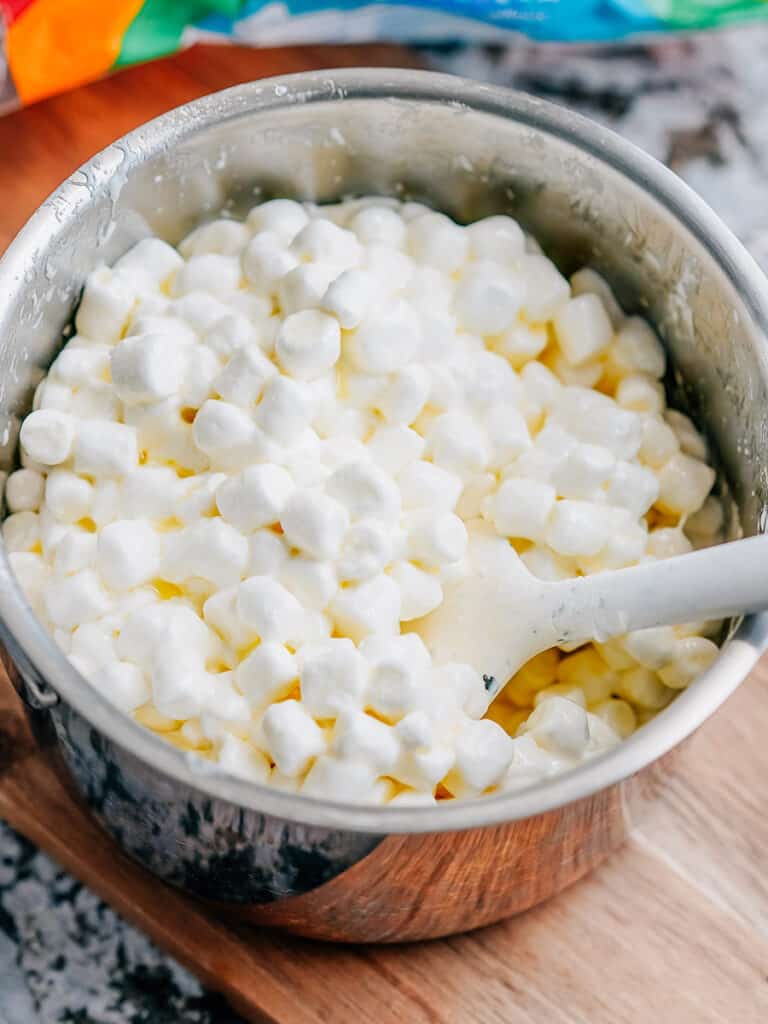 Melting mini marshmallows in a large saucepan with butter and vanilla extract.
