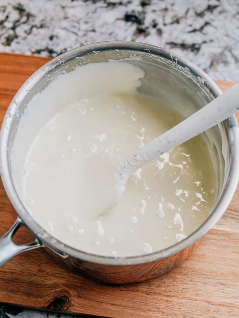 A large saucepan with melted marshmallows, butter, and vanilla extract smoothly stirred together.