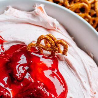 Mini twist pretzels stuck in this quick and simple dip made of strawberry pie filling, cream cheese, and cool whip.