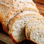 Fluffy white peasant bread with a buttery crust sliced and ready to eat.