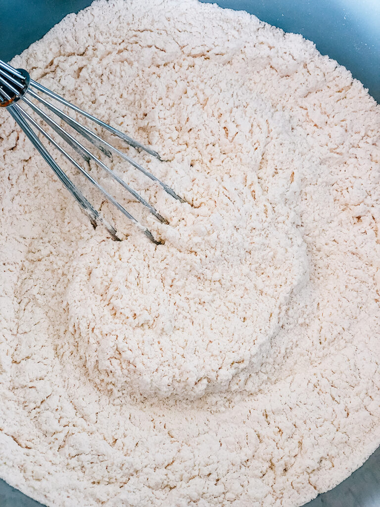 Flour, salt, sugar, and yeast whisked together and ready to add the wet ingredients.