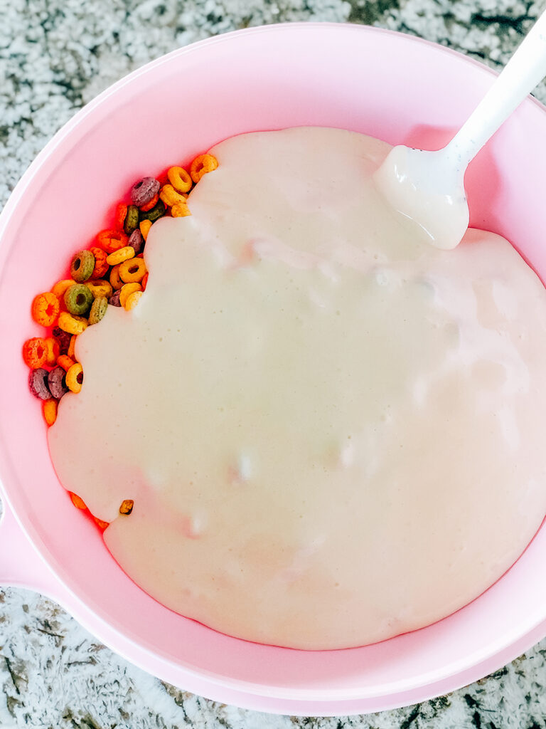 Melted marshmallows poured over a bowl of fruit rounds/froot loops.