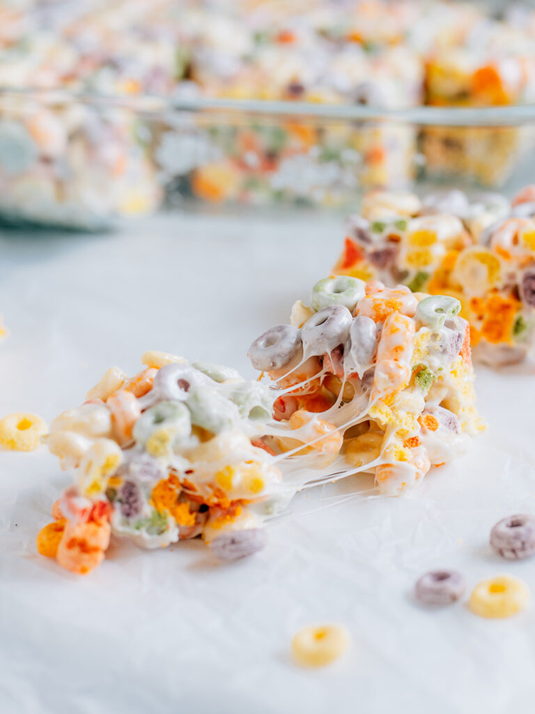 A pulled apart Froot Loop Cereal Treat showing the gooey marshmallow goodness inside.