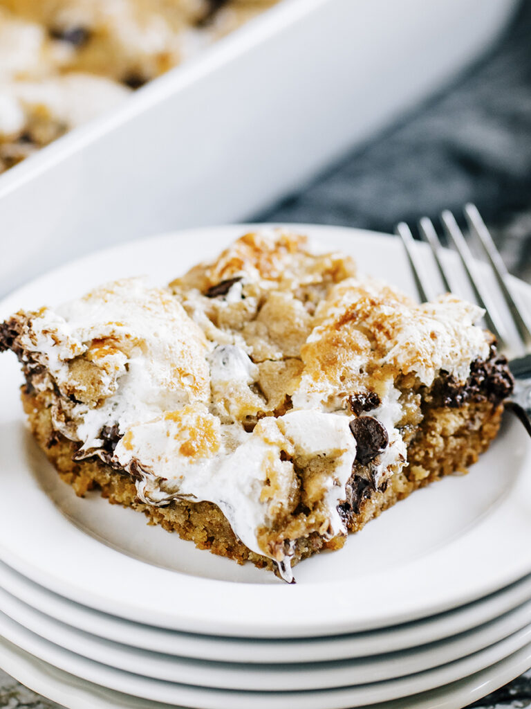 Melted chocolate chips and marshmallow creme on top of a soft and chewy graham cracker cookie crust is this S'more Cookie Bar recipe.