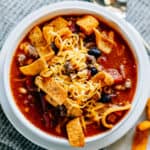 The perfect blend of taco soup and chili, this bowl of Santa Fe Soup topped with Chili Cheese Fritos and shredded cheese hits the spot!