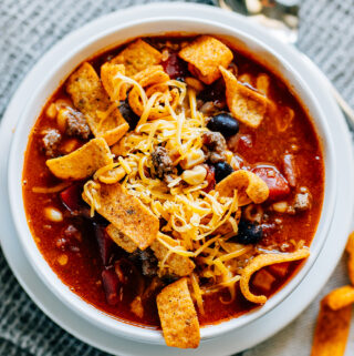 The perfect blend of taco soup and chili, this bowl of Santa Fe Soup topped with Chili Cheese Fritos and shredded cheese hits the spot!