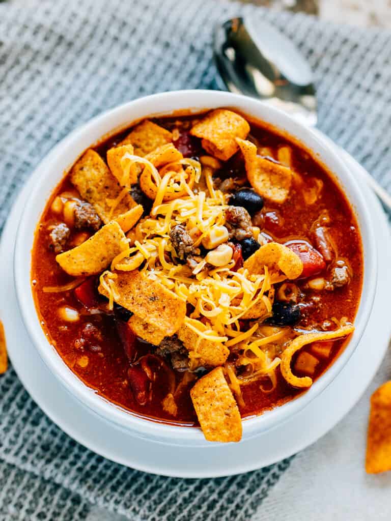 The perfect blend of taco soup and chili, this bowl of Santa Fe Soup topped with Chili Cheese Fritos and shredded cheese hits the spot!