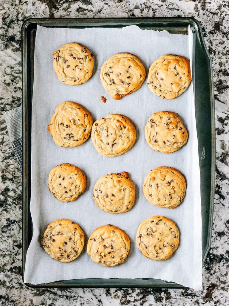 A baking sheet full of delicious freshly baked chocolate chip cookies.