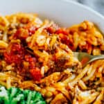 Close up photo of this casserole topped with homemade salsa and on a fork.